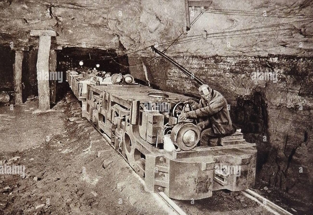 an-early-photograph-in-a-coal-mine-showing-the-introduction-of-motorised-trains-to-transport-t...jpg